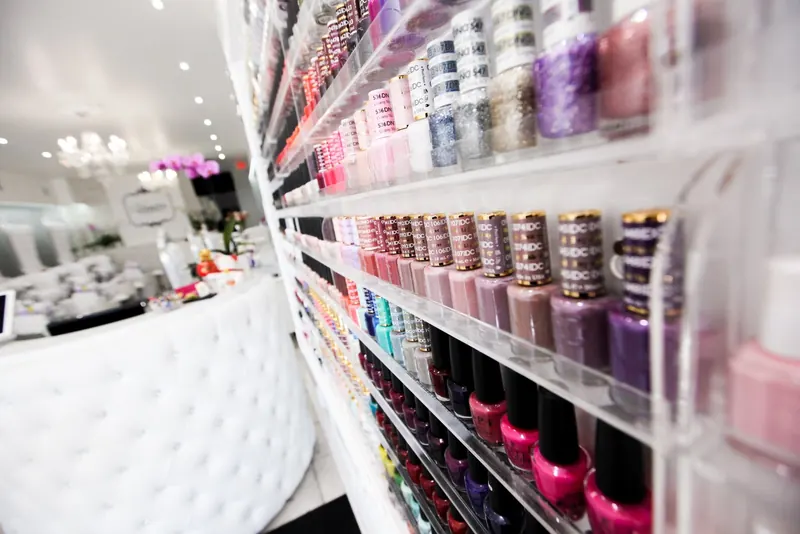 Shelves of nail polish beside a white chair